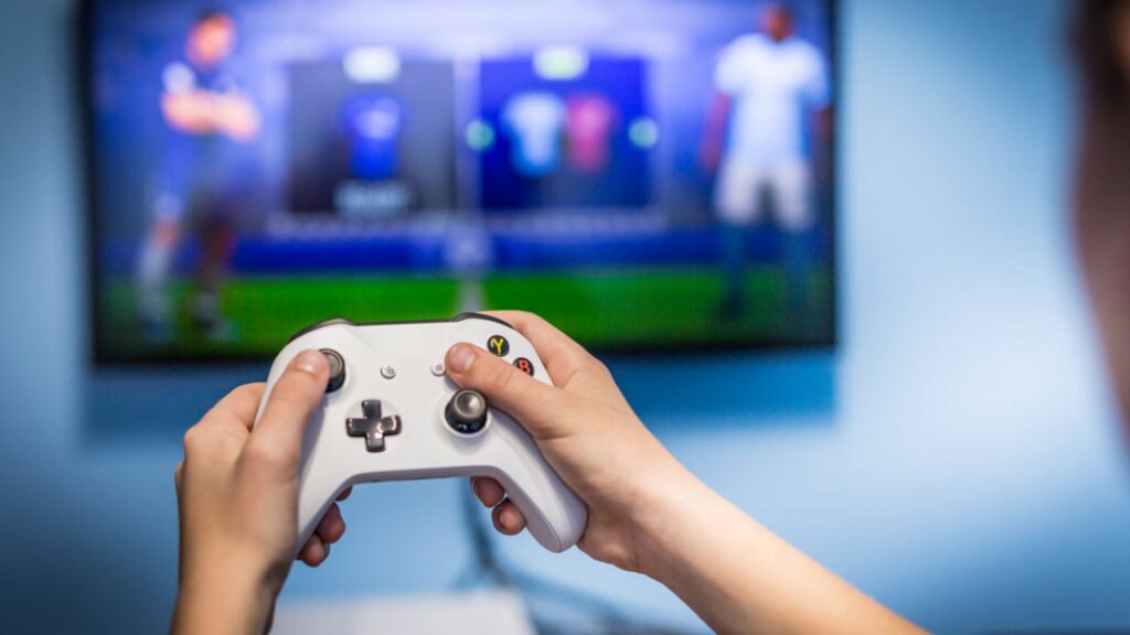 A picture of two hands using xbox controllers to play a game